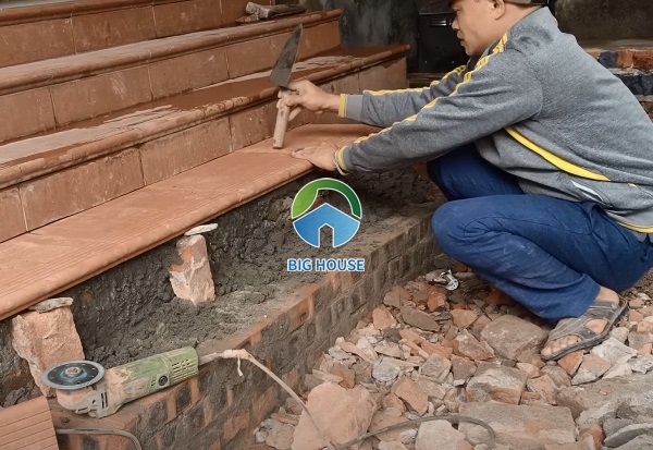 Thợ thi công lát gạch đỏ cotto cho bậc thềm nhà